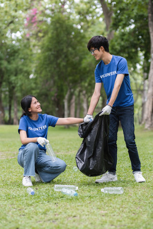 Volunteers Collecting Trash in a Park to Promote Environmental Awareness and Community Cleanlinessの写真素材