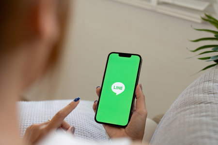 CHIANG MAI, THAILAND - Jun 25 ,2024: Woman holding Apple iPhone 14 with LINE apps on screen. LINE is a new communication app which allows you to make free voice calls and send free messagesのeditorial素材