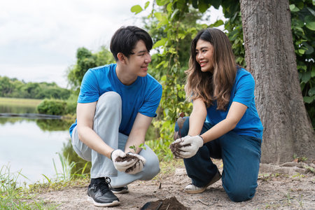 Volunteer Team Planting Trees and Caring for Nature in a Park Setting to Promote Environmental Conservation and Sustainabilityの写真素材