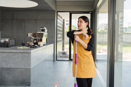 Dedicated Coffee Shop Cleaning Staff Ensuring a Spotless and Welcoming Environment for Customersの写真素材