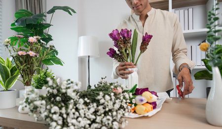 Young Man Relaxing in His Modern Room with Bookshelves and Flowers, Enjoying Leisure Time at Homeの写真素材