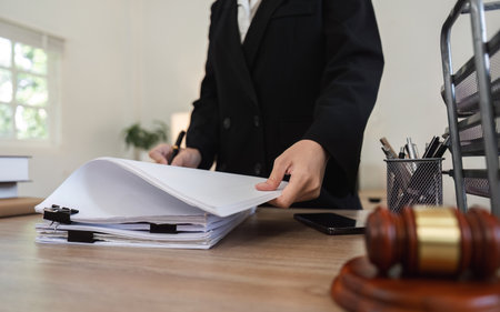 Young Lawyer Introducing and Signing Contract Documents with Clients in a Modern Office Settingの写真素材