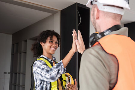 Engineering Team Celebrates Successful Project Completion with High-Five in Modern Office Environmentの写真素材