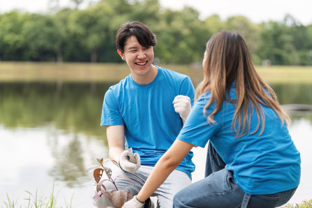 Volunteer Couple Planting Trees Together in a Park, Promoting Environmental Conservation and Community Serviceの写真素材