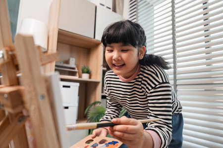 Young Girl Enjoying Her Hobby of Drawing and Painting at Home in a Creative and Modern Environmentの写真素材