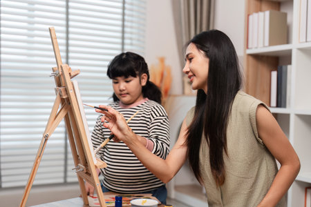 Mother and Daughter Enjoy Quality Time Together Creating Art and Drawing Pictures at Homeの写真素材