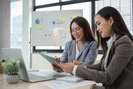 Business Woman Consulting with Colleagues in Modern Office Setting, Discussing Data and Strategiesの写真素材