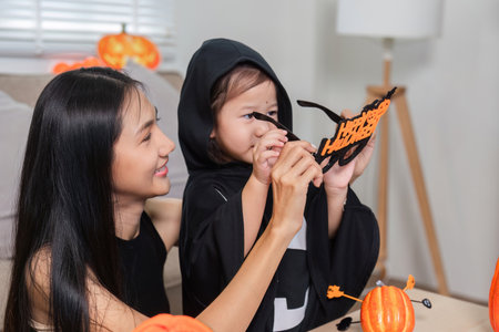 Mother and Daughter Enjoy Halloween Activities Together, Creating Fun Memories with Costumes and Craftsの写真素材