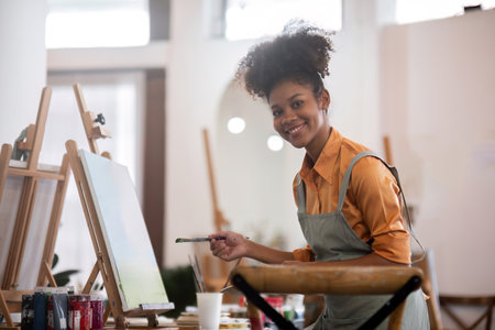 Young Girl Joyfully Drawing in a Bright and Modern Painting Studio with Art Supplies and Easels