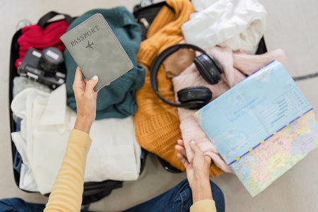Young Woman Preparing Passport and Packing for Exciting Tourist Trip with Essentials and Travel Map
