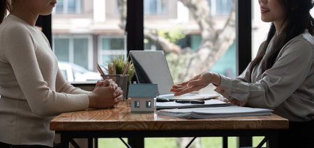 Real Estate Agents Presenting Home Project Plans to Clients in Modern Office Settingの写真素材