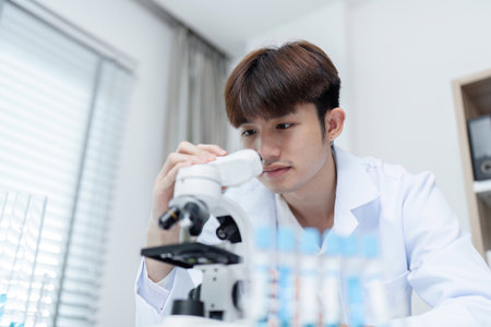 Scientist Examining Substance Under Microscope in Modern Laboratory Setting for Scientific Research and Analysisの写真素材