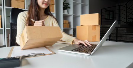 Young Woman Checking Customer Orders Online While Selling Products from Home Office