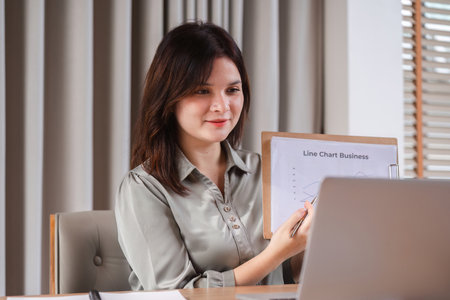 Focused Businesswoman Analyzing Documents and Strategizing Work Plans in a Modern Office Setting