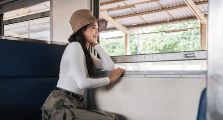 Asian woman enjoying train ride and scenic view, concept of relaxationの写真素材