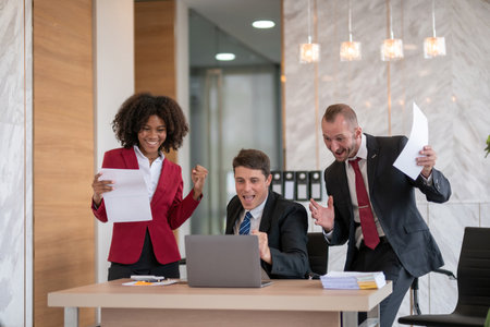 Diverse business team celebrating success at office desk, Concept of teamworkの写真素材