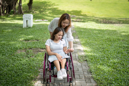 Young Disabled Woman and Best Friend Enjoying Outdoor Activities Together in a Park Settingの写真素材