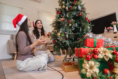 Festive Family Scene: Couple and Young Woman Joyfully Decorating Room for Christmas Celebration with Tree and Giftsの写真素材