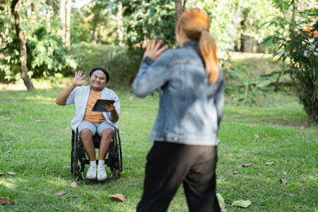 Disabled Young Man in Wheelchair Cheerfully Greets Friend in Park Setting, Embracing Friendship and...