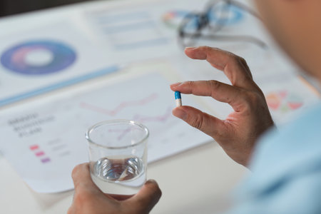 Taking medicine for sick or unwell moments at home health awareness lifestyle indoor close-up well-beingの写真素材