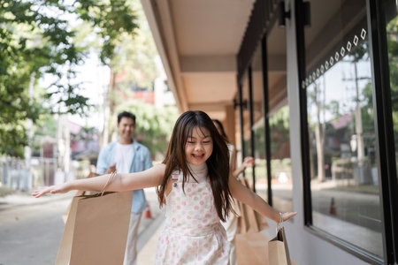 Joyful Family Shopping Experience with Smiling Parents and Children in a Modern Urban Settingの写真素材