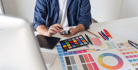 Graphic Designer Selecting Color Pairs on Computer for Creative Design Projects in Modern Workspace...
