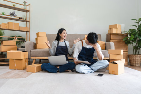 Stressed Couple Managing Online Sales for Small Business Surrounded by Shipping Boxes