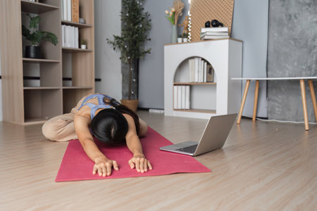 Young Healthy Woman Practicing Yoga at Home in a Modern Living Room Setting with Natural Light and...