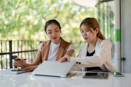 Confident Businesswoman Providing Guidance to New Employee in Modern Office Settingの写真素材