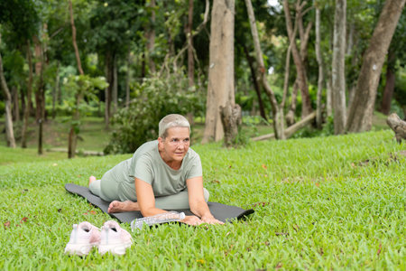 Elderly Woman Practicing Yoga Outdoors in a Peaceful Park Setting, Embracing Wellness and...