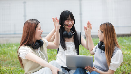 Students Collaborating Outdoors at University. Teamwork and Knowledge Sharing. Students Engaged in Collaborative Learning Outdoors.の写真素材