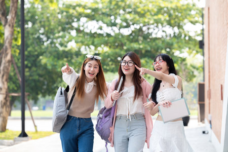 Students walking together and smiling outdoors at university campusの写真素材