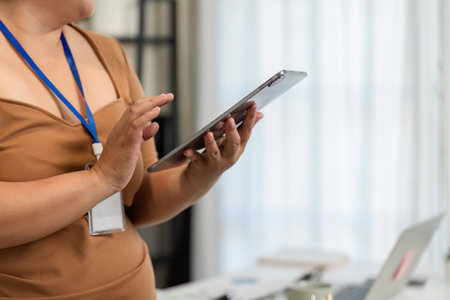 Professional woman using a tablet for a presentation in a bright office environment
