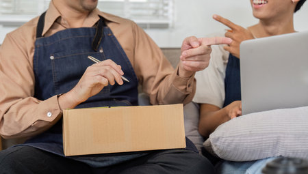 Delivery professionals playfully pointing while discussing packages in a cheerful workspace