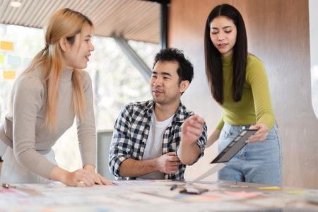 Diverse professionals discussing ideas and reviewing documents in office.の写真素材