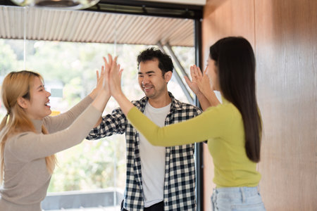 Diverse colleagues celebrating teamwork and success in a modern office environment.