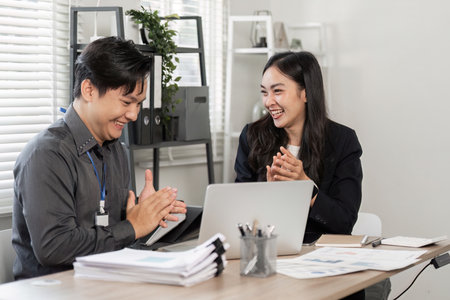 Diverse business partners discussing ideas and sharing laughter in the office.の写真素材