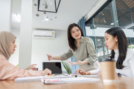 Diverse financial team discussing strategies in a modern office setting, showcasing collaboration and professionalism.の写真素材