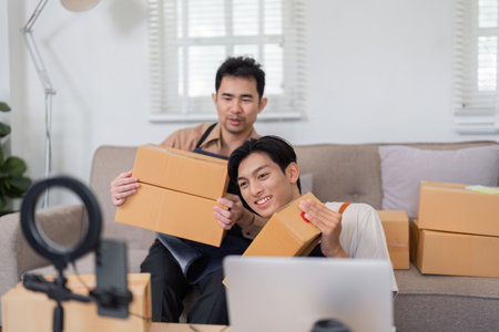 Diverse online sellers preparing packages for shipment at home, collaborating on e-commerce business.の写真素材