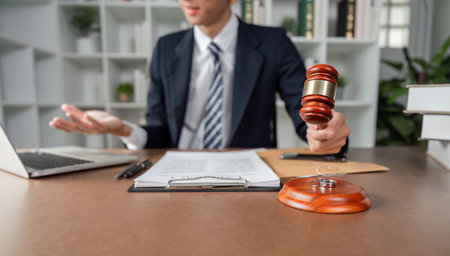 Lawyer explaining legal matters while holding gavel, engaged in discussion at modern office desk.