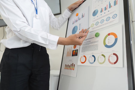 Close-up of a professional presenting financial data on a board in an office.