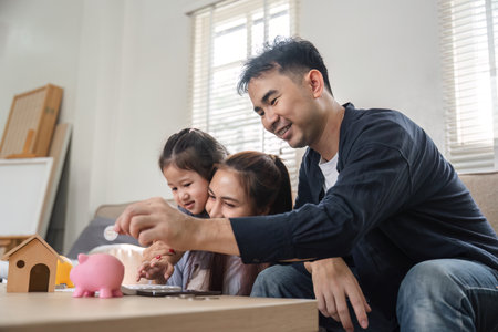 Family enjoying savings activity together, teaching children about money managementの写真素材