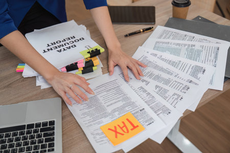 Accountant organizing tax documents and financial reports on a desk