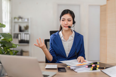 Accountant providing financial consultation via headset in a modern office.の写真素材