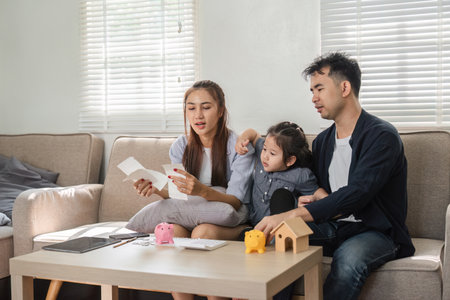 Family budgeting and saving together at home, focusing on financial planning.
