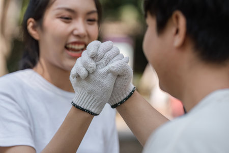 Young friends celebrating their teamwork, showcasing joy and environmental responsibility.の写真素材