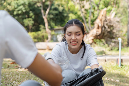 Young woman enjoying a community cleanup while collecting plastic wasteの写真素材