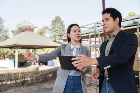 Collaborative business analysis. Team discussing solar energy initiatives outdoors.の写真素材