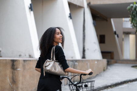Sustainable Living and Urban Commuting. A young woman looks back while cycling, embracing a vibrant and healthy lifestyle.の写真素材
