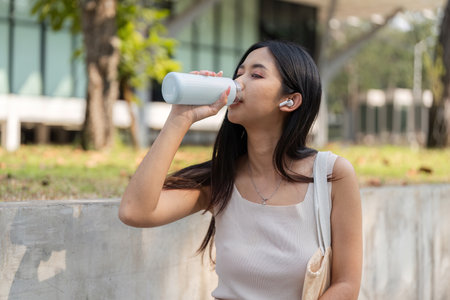 Sustainable lifestyle. Woman drinking from a reusable cup outdoors.の写真素材